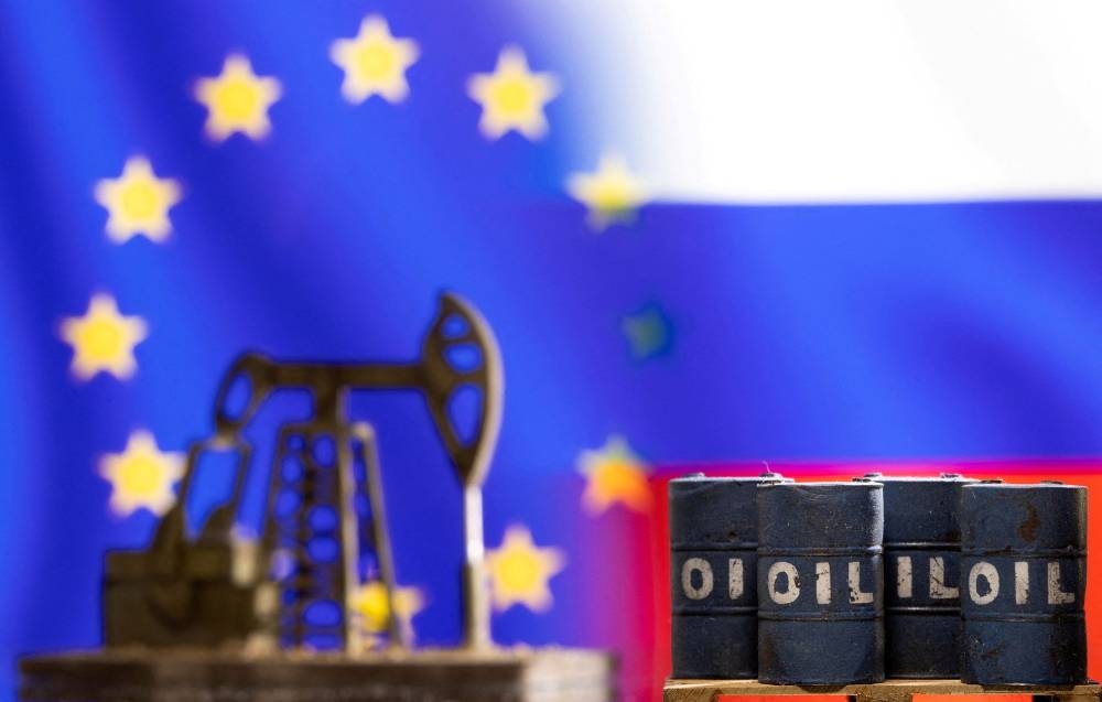 Models of oil barrels and a pump jack are seen in front of displayed EU and Russia flag colours in this illustration taken March 8, 2022. — Reuters pic