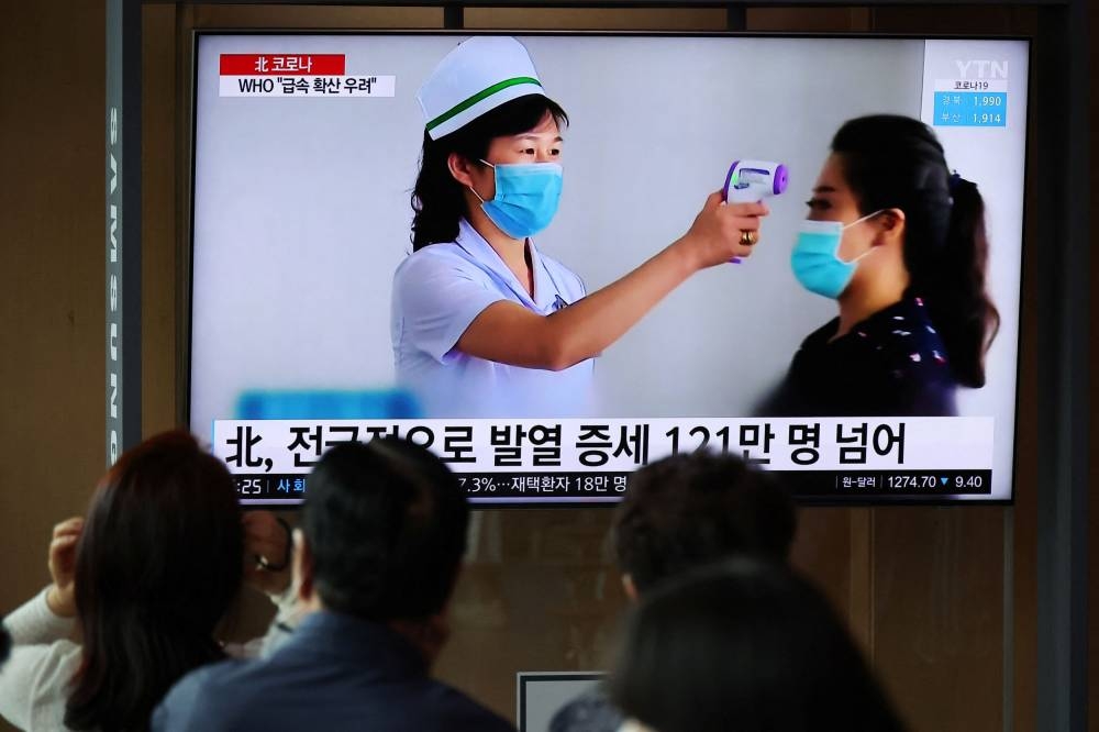 People watch a TV broadcasting a news report on the Covid-19 outbreak in North Korea, at a railway station in Seoul, South Korea May 17, 2022. ― Reuters pic