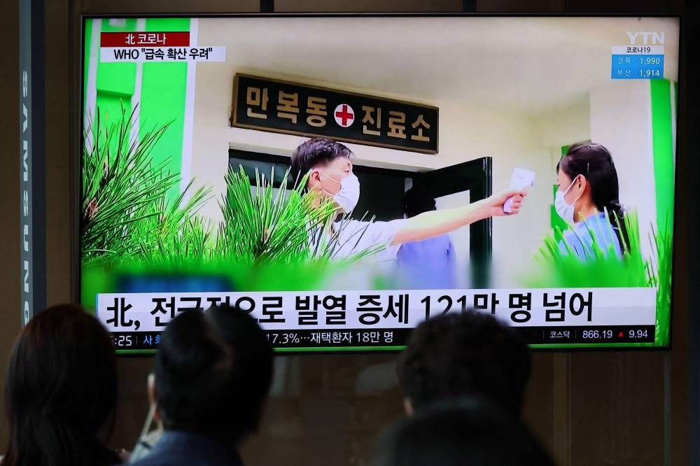 People watch a TV broadcasting a news report on the Covid-19 outbreak in North Korea, at a railway station in Seoul, South Korea May 17, 2022. ― Reuters pic