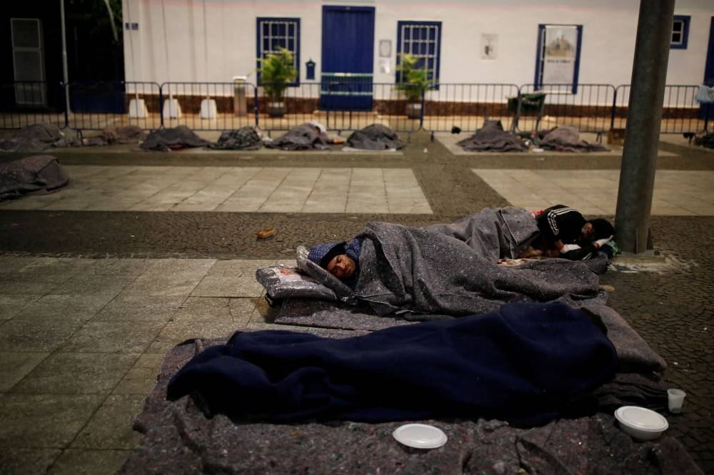 Homeless people lay down on the floor as some sleep during cold temperatures in downtown Sao Paulo, Brazil May 18, 2022. — Reuters pic