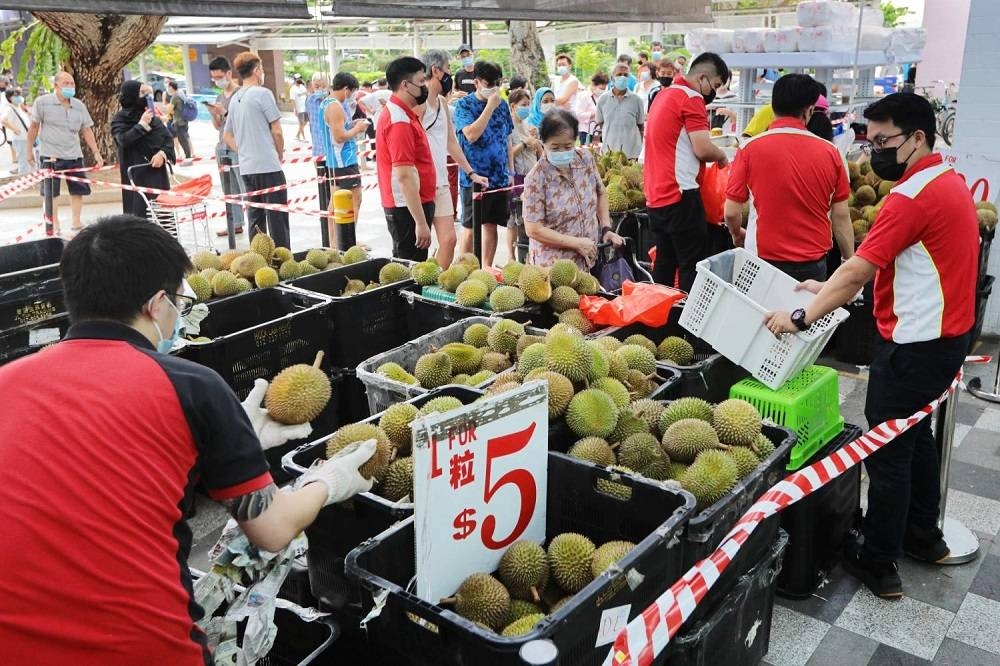 People in Singapore queueing to buy durians in June 2021. — Reuters pic 