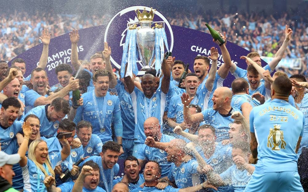 Manchester City's Fernandinho lifts the trophy as he celebrates with teammates after winning the Premier League at the Etihad Stadium, Manchester, May 22, 2022. — Reuters pic