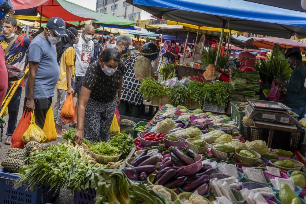 People wearing face masks shop for fresh produce at the Jalan Pudu market in Kuala Lumpur May 17, 2022. — Picture by Shafwan Zaidon