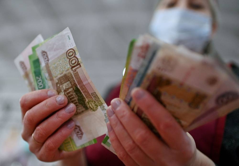 A vendor counts Russian rouble banknotes at a market in Omsk, Russia February 18, 2022. ― Reuters file pic