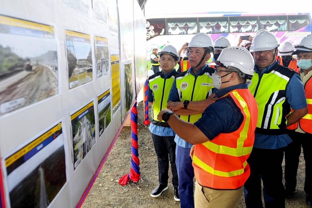 Senior Works Minister Datuk Seri Fadillah Yusof (2nd right) getting briefed on the Sabah Pan Borneo Highway in Sandakan, May 27, 2022. — Bernama pic  