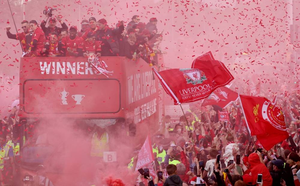 General view of confetti and red smoke as Liverpool players celebrate on board an open top bus during the victory parade in Liverpool, May 29, 2022. — Reuters pic 