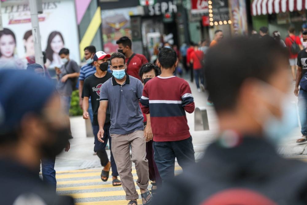 People are seen walking in the Bukit Bintang area in Kuala Lumpur February 9, 2022. — Picture by Hari Anggara