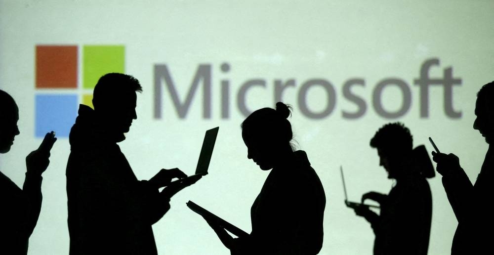 Microsoft warns of forex hit, cuts forecast