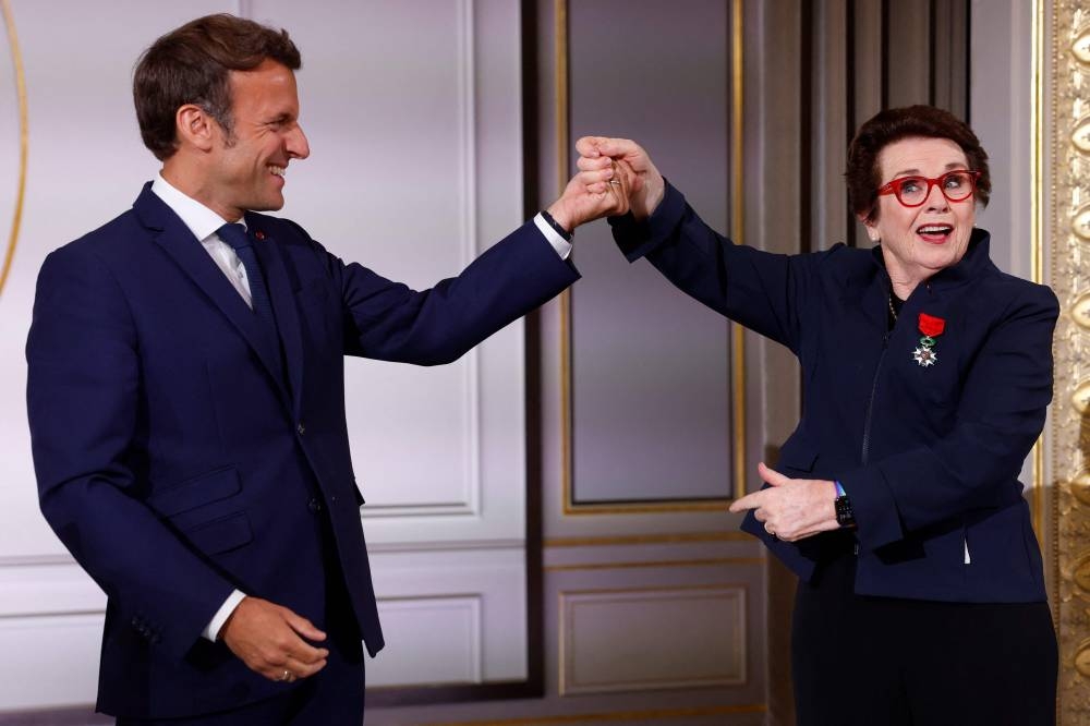 French President Emmanuel Macron holds the hand of tennis legend Billie Jean King, of the US, after awarding her with the Legion of Honour at the Elysee Palace June 3, 2022 in Paris. — AFP pic