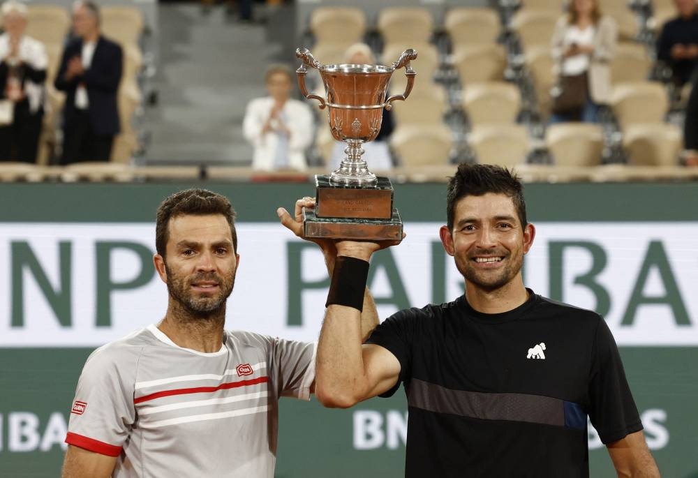 El Salvador's Marcelo Arevalo and Netherlands' Jean-Julien Rojer celebrate with the trophy after winning their men's doubles final match against Croatia's Ivan Dodig and Austin Krajicek of the US. — Reuters pic