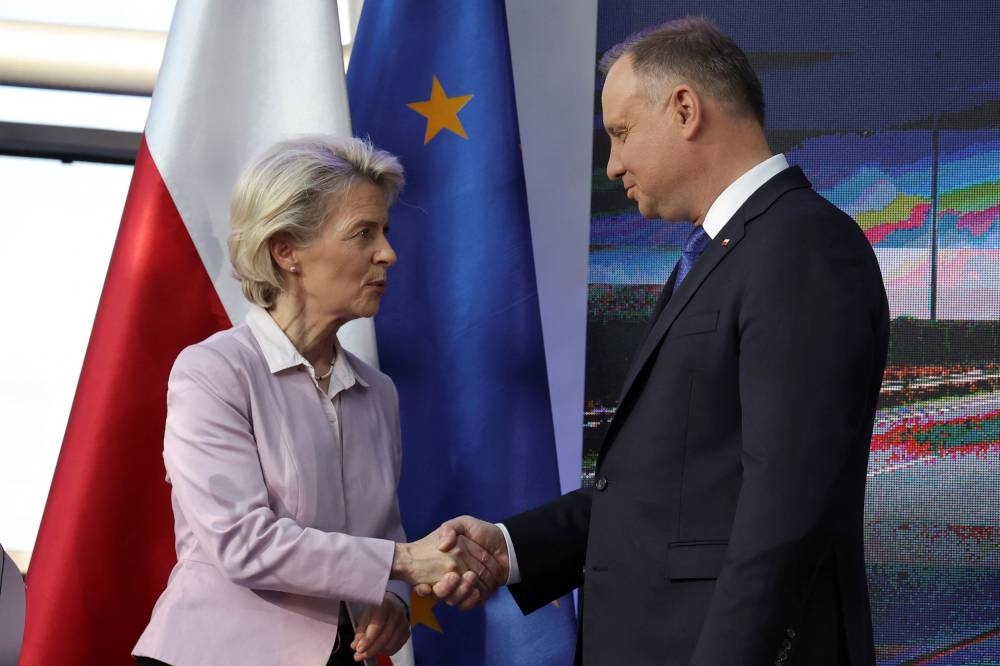 European Commission President Ursula von der Leyen shakes hands with Polish President Andrzej Duda during her visit to Poland to mark the acceptance of the country's National Recovery Plan, which will unlock large coronavirus disease (Covid-19) pandemic recovery funds, in Warsaw, Poland June 2, 2022. — Reuters pic