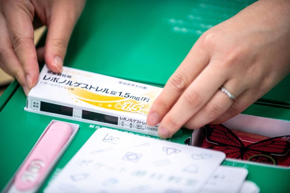 This picture taken on June 8, 2022 shows pharmacist Reina Suzuki puts a box of morning after pills into a fertility control kit at a pharmacy in Tokyo. — ETX Studio pic