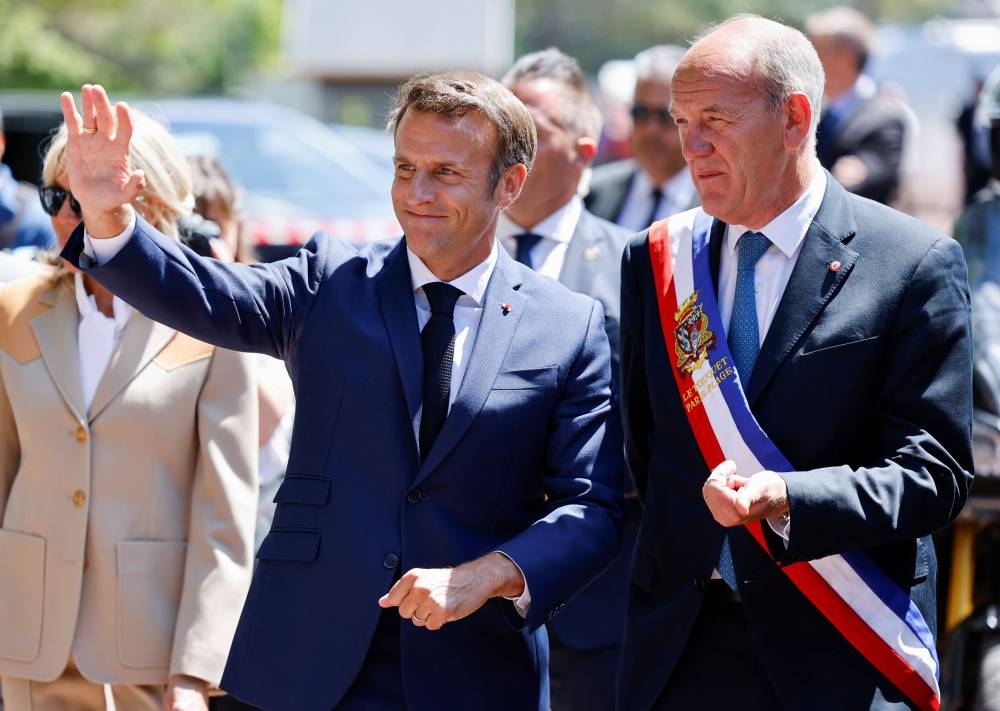 French President Emmanuel Macron gestures as he walks with Touquet's mayor Daniel Fasquelle during the first round of French parliamentary elections, at a polling station in Le Touquet, France June 12, 2022. — Ludovic Marin/Pool via Reuters