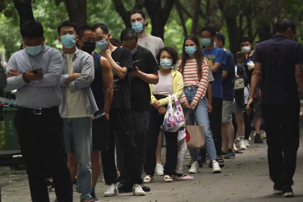 People line up for nucleic acid tests at a mobile testing booth, following the Covid-19 outbreak, in Beijing, China June 13, 2022. — Reuters pic