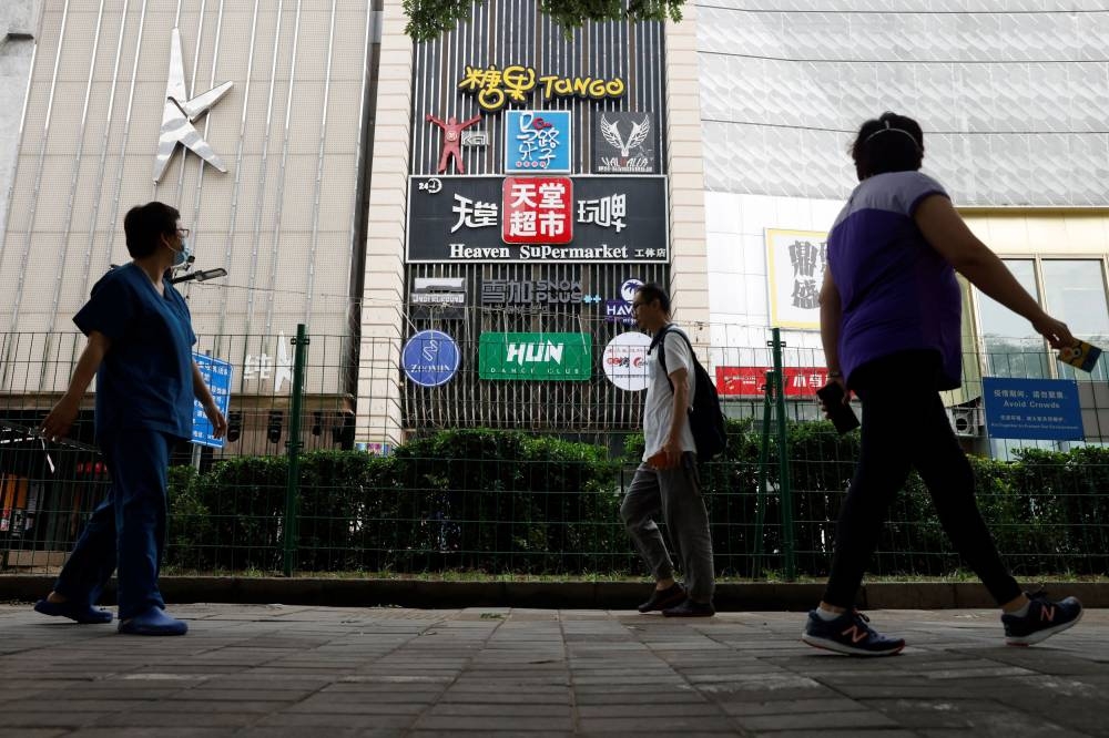 People walk past fences outside the Heaven Supermarket bar, where a Covid-19) outbreak emerged, in Chaoyang district of Beijing, China June 13, 2022. — Reuters pic