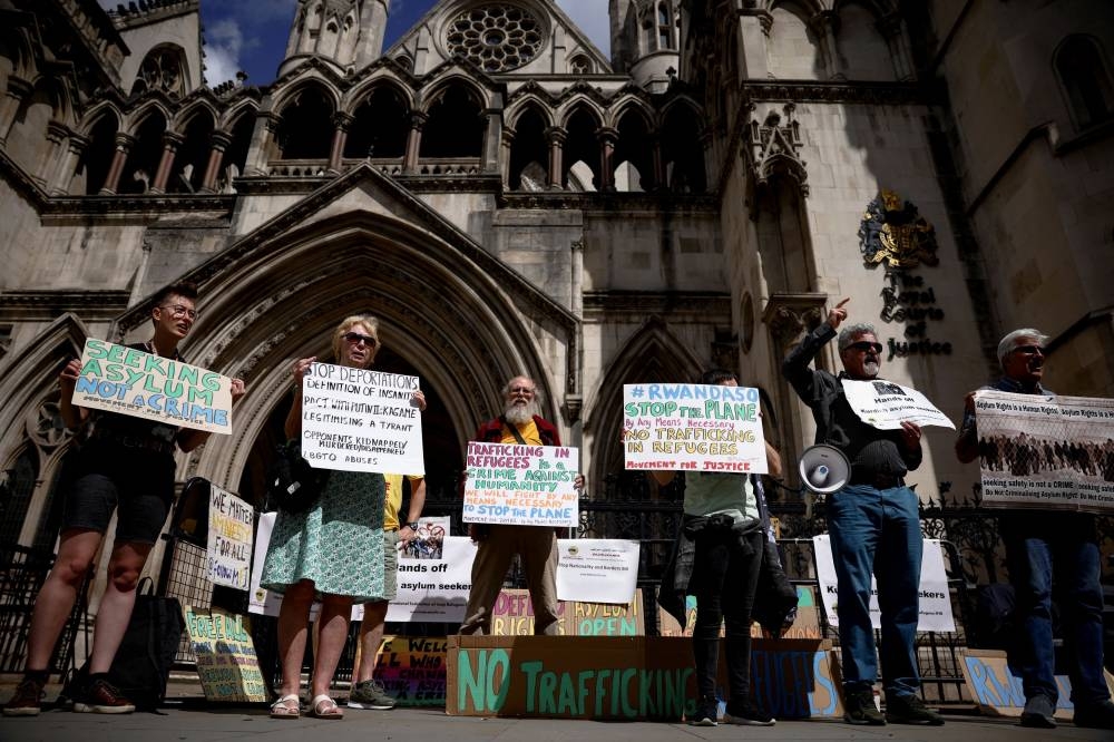 Demonstrators display placards during a protest outside the Royal Courts of Justice whilst a legal case is heard over halting a planned deportation of asylum seekers from Britain to Rwanda, in London June 13, 2022. — Reuters pic