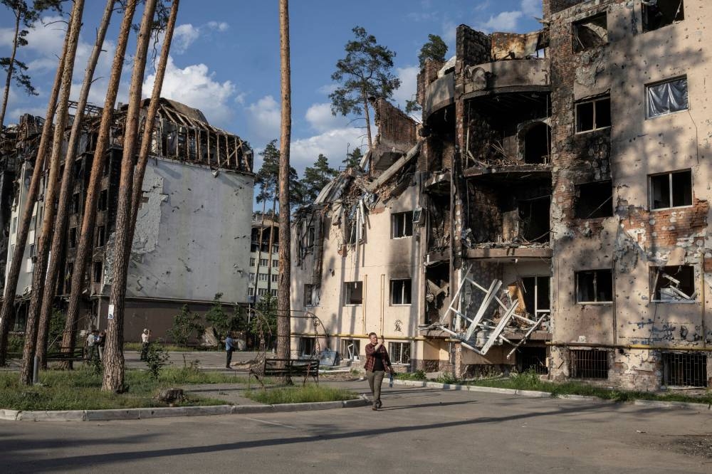 People look at destroyed buildings in Irpin, outside Kyiv, as Russia's attacks on Ukraine continues, June 9, 2022. — Reuters pic