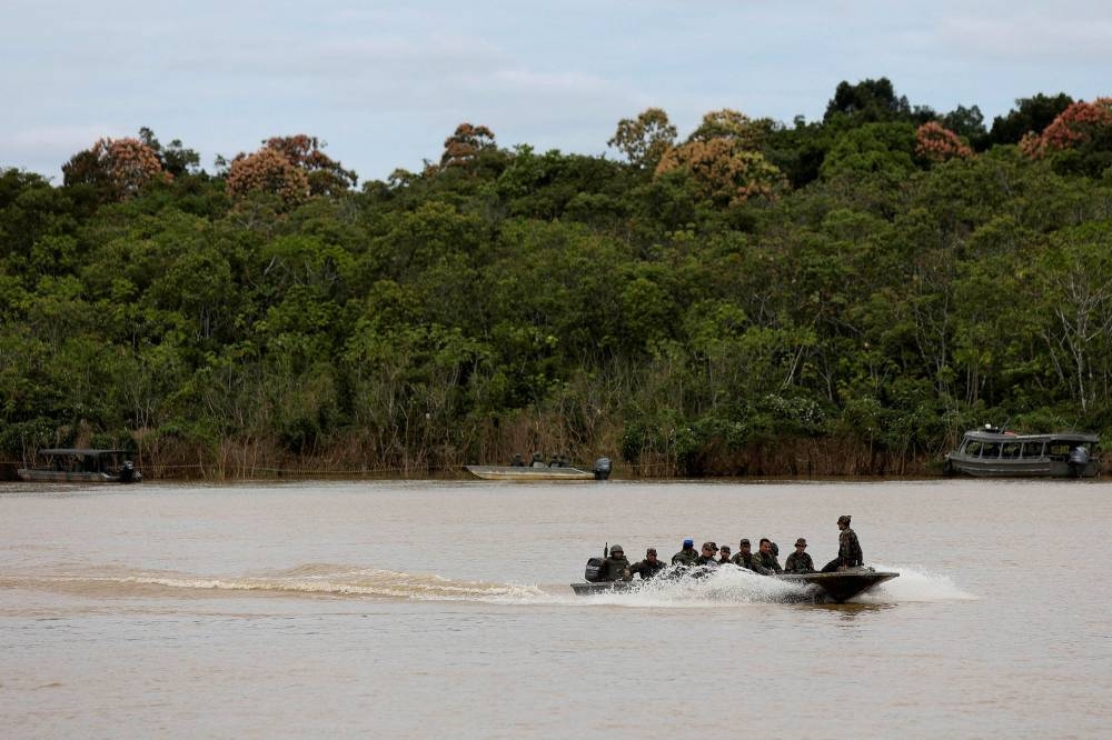 Brazilian soldiers sit on a boat during the search operation for British journalist Dom Phillips and indigenous expert Bruno Pereira, who went missing while reporting in a remote and lawless part of the Amazon rainforest, near the border with Peru, in Atalaia do Norte, Amazonas state June 12, 2022. — Reuters pic