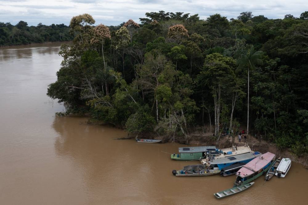 Aerial view showing indigenous members of the Union of Indigenous Peoples of the Javari Valley (Univaja) who are looking for clues that lead to the whereabouts of veteran correspondent Dom Phillips and respected indigenous specialist Bruno Pereira, gathering on the banks of the Itagua river in Vale do Javari, municipality of Atalaia do Norte, state of Amazonas, Brazil, on June 13, 2022. — AFP pic