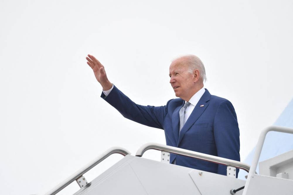 US President Joe Biden waves as he makes his way to board Air Force One before departing from Andrews Air Force Base in Maryland on at Joint Base Andrews, Maryland on June 14, 2022. — AFP pic