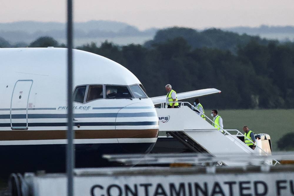 Members of the staff board a plane reported by British media to be first to transport migrants to Rwanda, at MOD Boscombe Down base in Wiltshire, Britain, June 14, 2022. REUTERS/Henry Nicholls