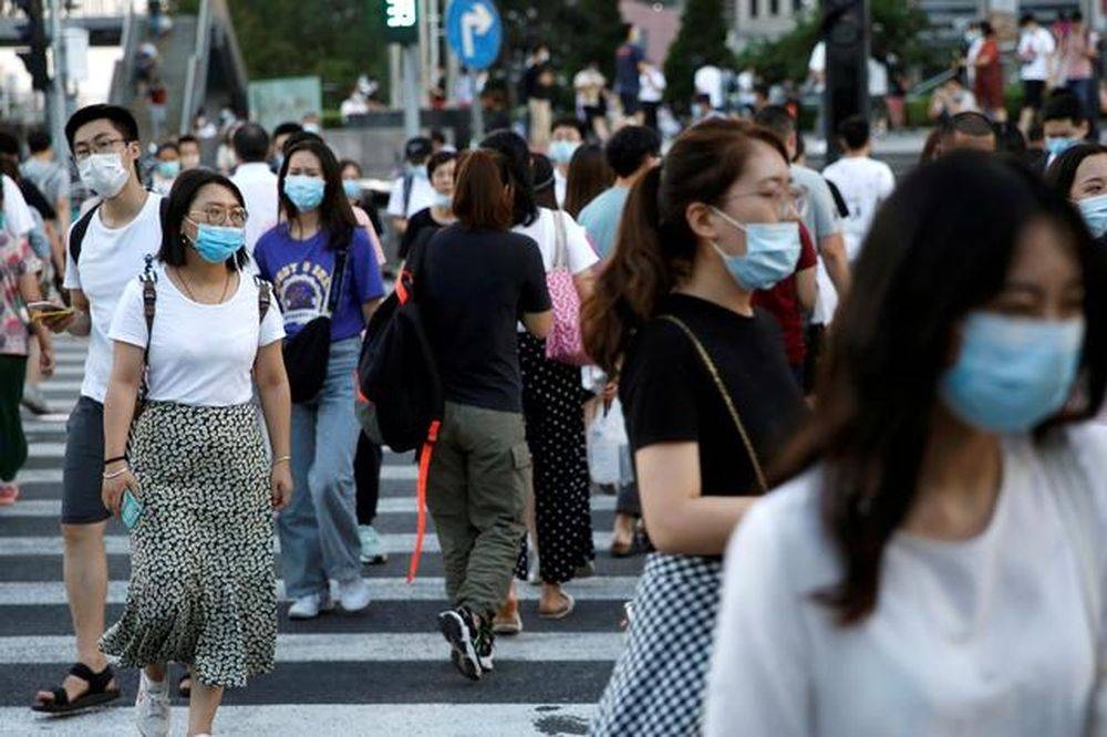 People wearing face masks as they walk across a street at a shopping area in Beijing, China August 25, 2020. ― Reuters pic