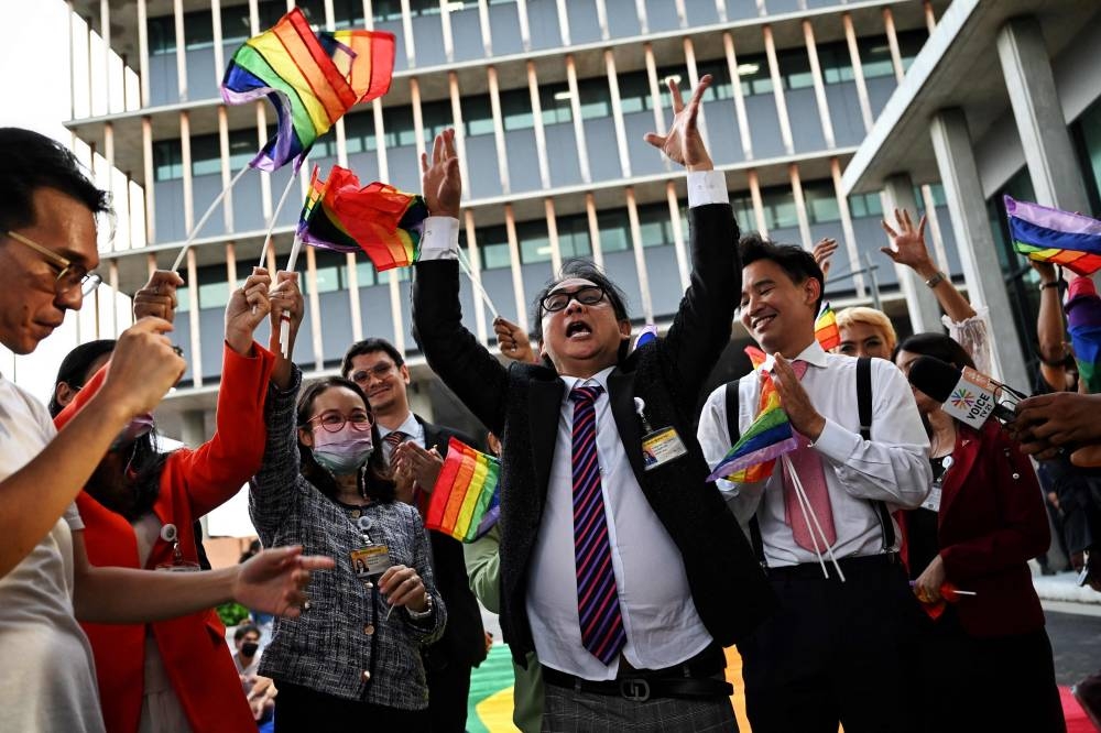 Members of Move Forward Party celebrate with LGBTQIA  activists and supporters after the initial passing of the Marriage Equality Bill outside parliament in Bangkok on June 15, 2022. — AFP pic