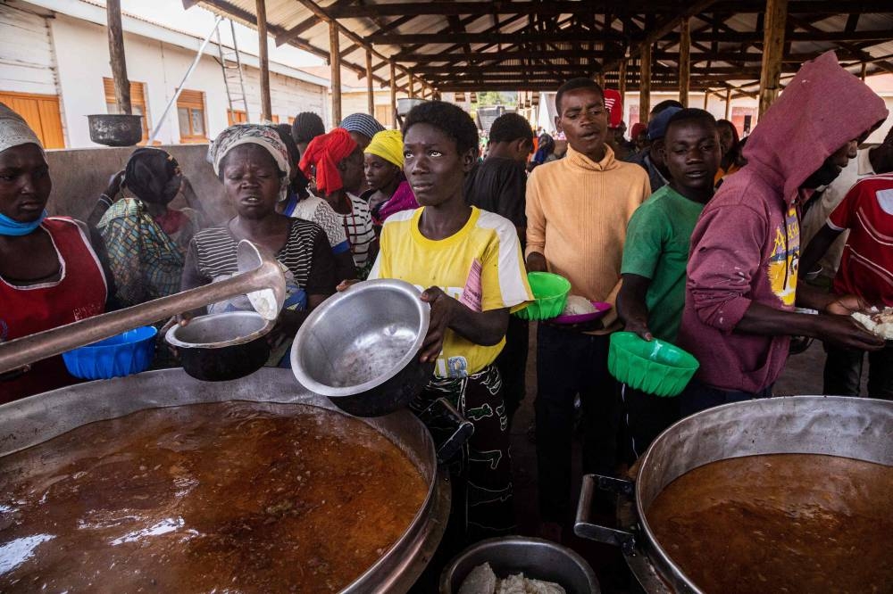 Refugees from the Democratic Republic of Congo (DRC) receive lunch at the Nyakabande Transit Center in Kisoro, Uganda, June 7, 2022. — AFP pic