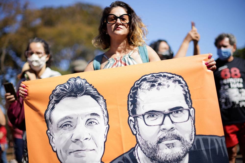 A woman holds a sign while taking part in a protest, to demand justice for journalist Dom Phillips and indigenous expert Bruno Pereira, who were murdered in the Amazon, in Brasilia, Brazil June 19, 2022. — Reuters pic