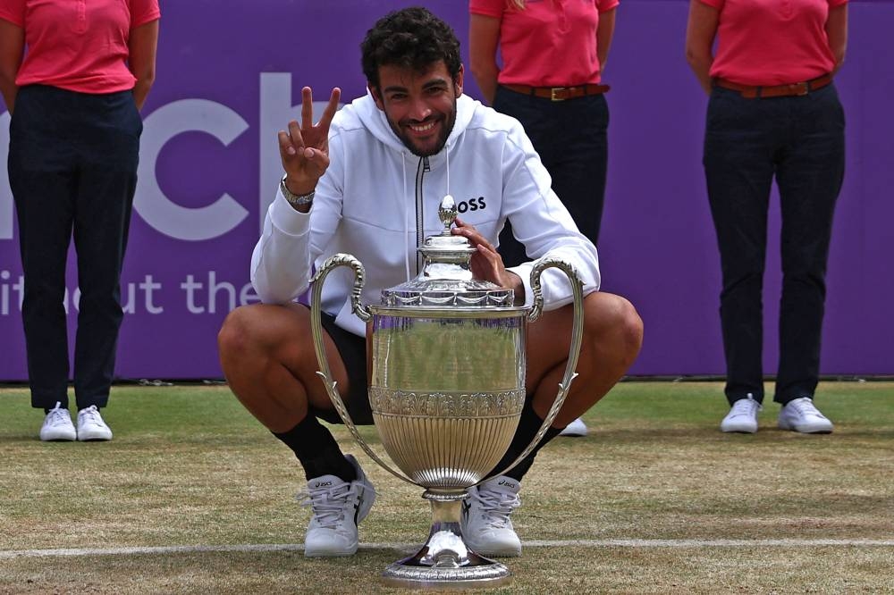 Italy's Matteo Berrettini poses for a photograph as he celebrates with the trophy after his win in his men's singles final tennis match against Serbia's Filip Krajinovic on Day 7 of the cinch ATP Championships at Queen's Club in west London, on June 19, 2022. — AFP pic