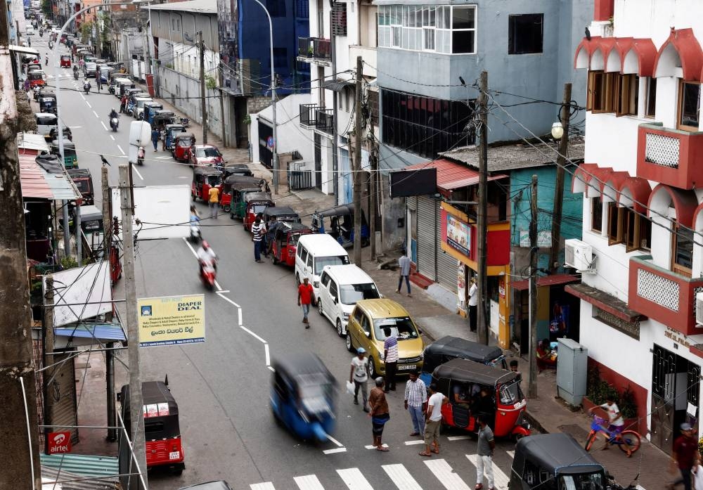 Vehicle owners wait in a queue to buy petrol due to fuel shortage, amid the country's economic crisis, in Colombo, Sri Lanka June 17, 2022. — Reuters pic