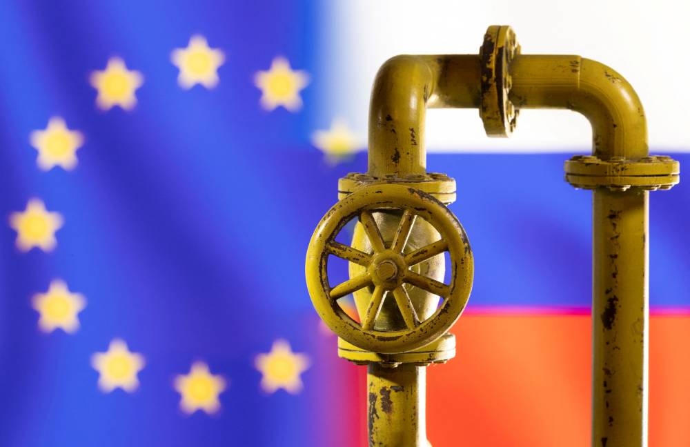 A model of the natural gas pipeline is seen in front of displayed word EU and Russia flag colours in this illustration taken March 8, 2022. — Reuters pic