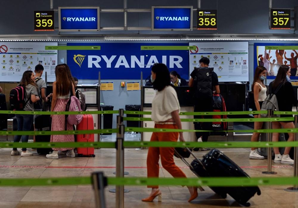 Passengers stand near the Ryanair check-in counters during a strike at Adolfo Suarez Madrid Barajas airport Madrid on June 24, 2022. — AFP pic