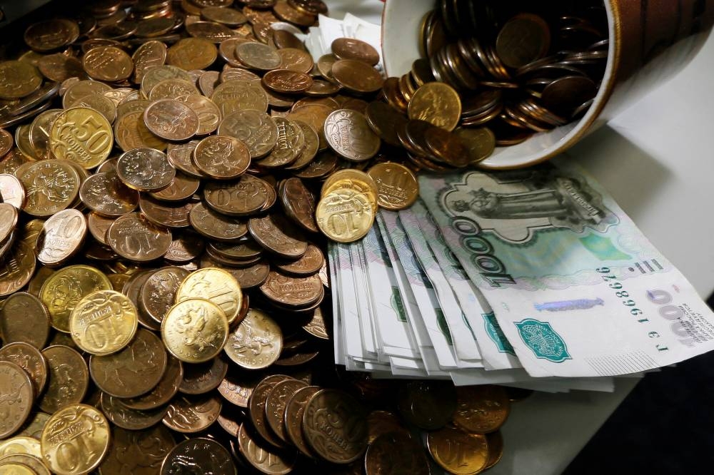 Russian 1000-rouble banknotes, 50 and 10 kopeck coins are seen on a table at a private company's office in Krasnoyarsk, Siberia November 6, 2014. — Reuters pic