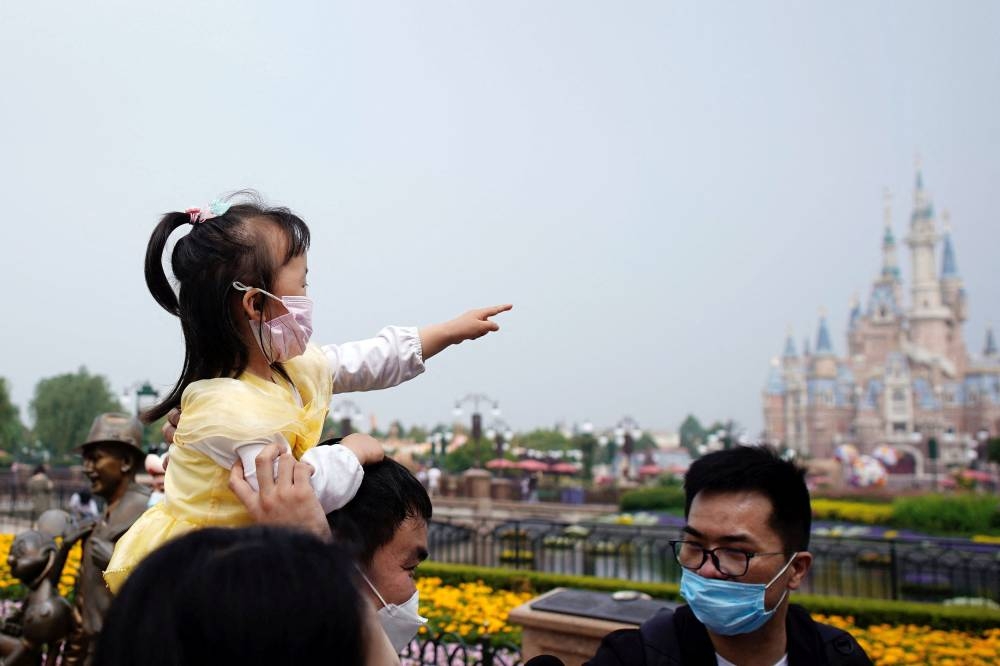 Visitors wearing face masks are seen at the Shanghai Disneyland theme park in Shanghai, China May 11, 2020. ― Reuters file pic