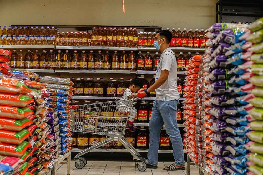 A man walks past bottles of cooking oil at a supermarket in Bayan Baru December 2, 2021. Last week, the PH Presidential Council had urged the government to come up with measures to address issues regarding subsidies and rising cost of living within 24 hours or resign following the removal of ceiling price of chicken and subsidies for cooking oil. — Picture by Sayuti Zainudin