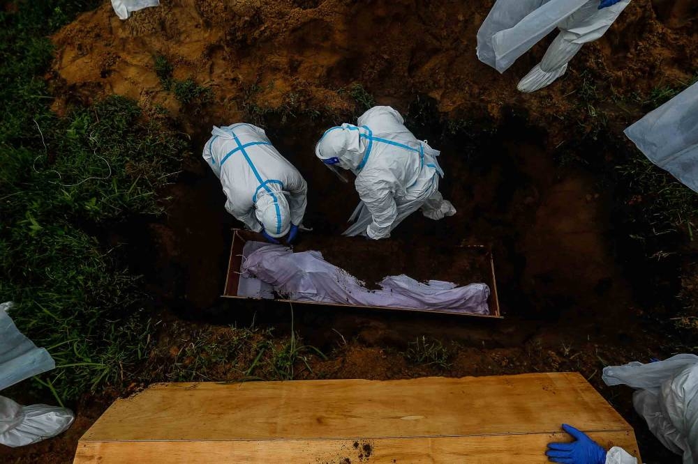 File picture of volunteers preparing a body for burial at Bagan Ajam Muslim Cemetery in Penang, August 24, 2021. Health Minister Khairy Jamaluddin today said under revised procedures for the management of remains of Muslim Covid-19 patients, the bodies can now be bathed and shrouded, with the adoption of precautionary measures. — Picture by Sayuti Zainudin