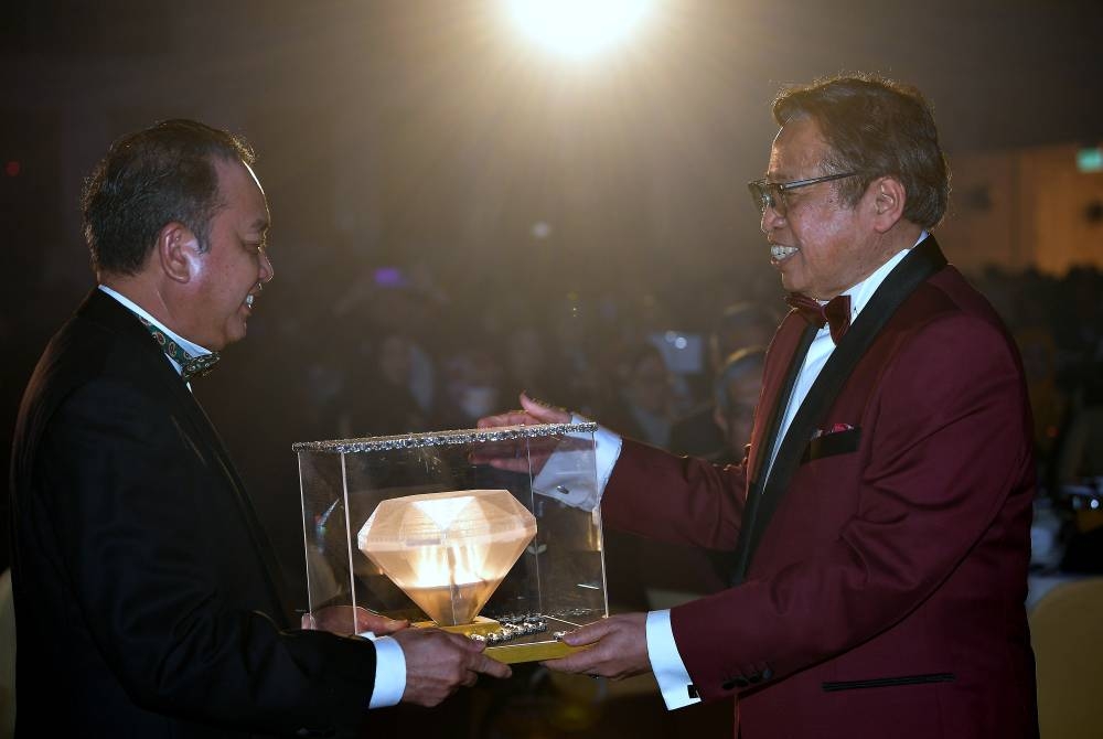 Sarawak Premier Tan Sri Abang Johari Openg hands over the Sarawak Economic Development Corporation’s new logo to its chairman Tan Sri Abdul Aziz Husain at SEDC’s 50th Anniversary Dinner in Kuching, July 4, 2022. — Bernama pic 