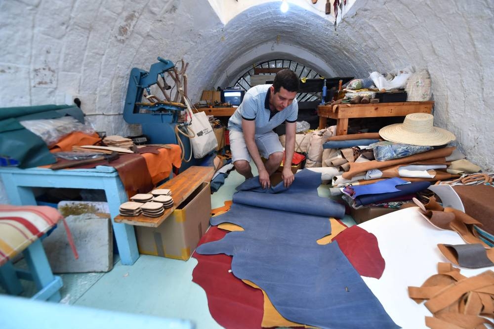 Tunisian craftsman Souhail Fitouri makes traditional leather slippers at his workshop in the old Medina of Tunis, on May 21, 2022. — AFP pic