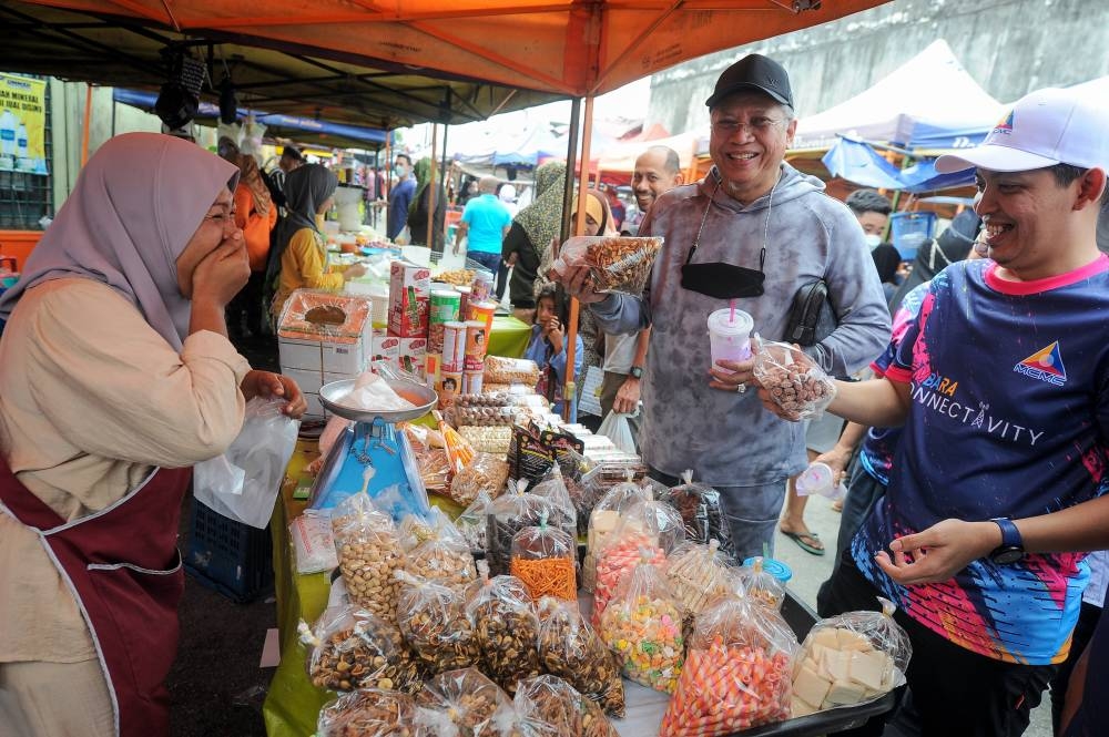 Tan Sri Annuar Musa visits tradeers at the local market in Ketereh, Kelantan, July 16, 2022. — Bernama pic