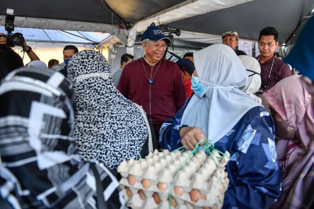 Communications and Multimedia Minister Tan Sri Annuar Musa meets residents while attending the Keluarga Malaysia Sales Auction programme in conjunction with the Kelantan Keluarga Malaysia Aspirations (AKM) Tour at the Sultan Muhammad IV Stadium in Kota Baru July 24, 2022. — Bernama pic