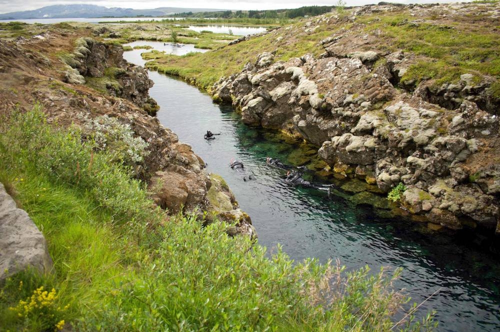 Snorkellers are pictured in the main Silfra fissure on July 26, 2022 in Thingvellir, Iceland. — AFP pic