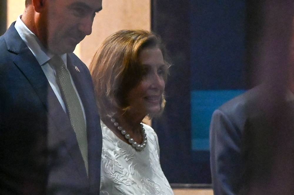 Speaker of the US House of Representatives Nancy Pelosi (right) leaves the Shangri-La Hotel after a reception organised by the American Chamber of Commerce in Singapore August 1, 2022. — AFP pic