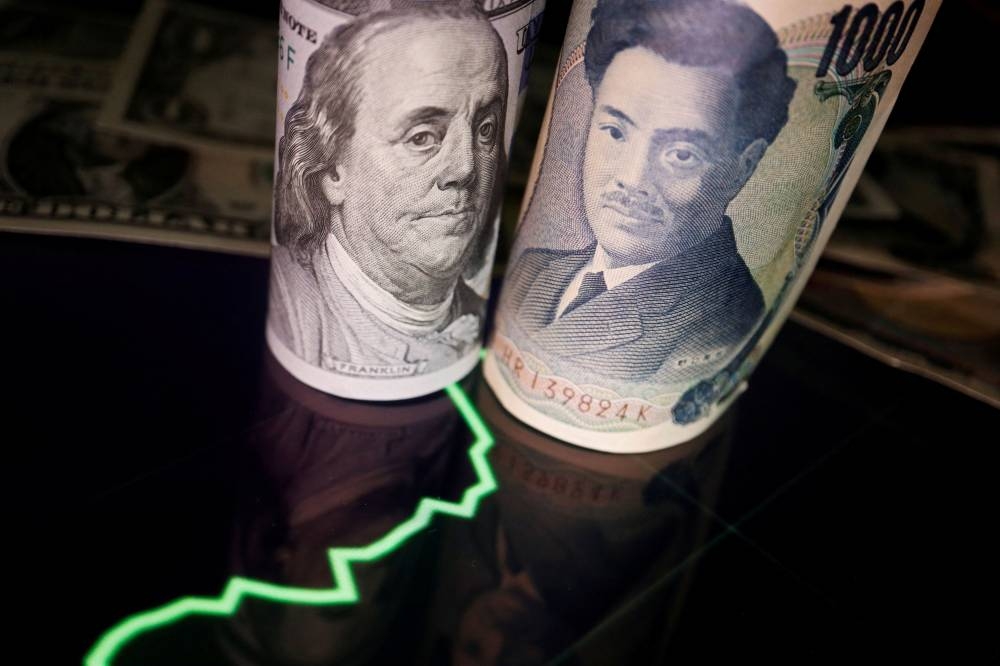 US dollar and Japanese yen banknotes are seen with a currency exchange rate graph in this illustration picture taken June 16, 2022. — Reuters pic