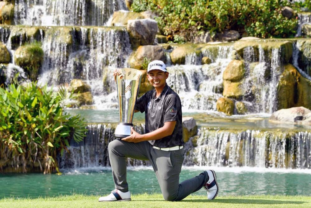 Nitihorn Thippong of Thailand posing with the winner’s trophy after the final round of the International Series Singapore golf tournament at Tanah Merah Country Club in Singapore, August 14, 2022. —Paul Lakatos/Asian Tour handout pic via AFP