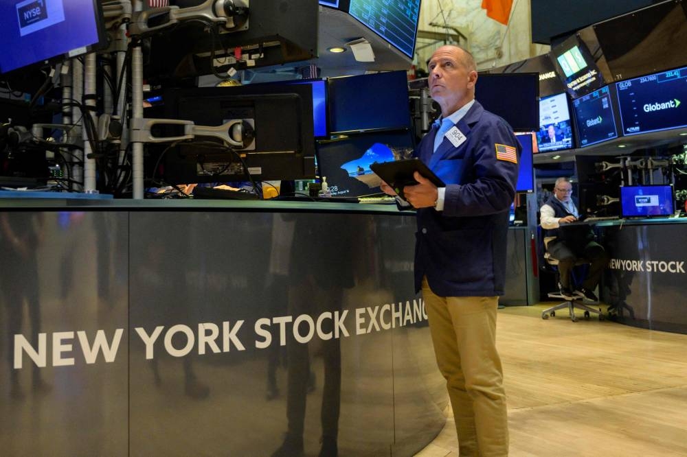 Traders work during the opening bell at the New York Stock Exchange (NYSE) on August 16, 2022 at Wall Street in New York City. — AFP pic