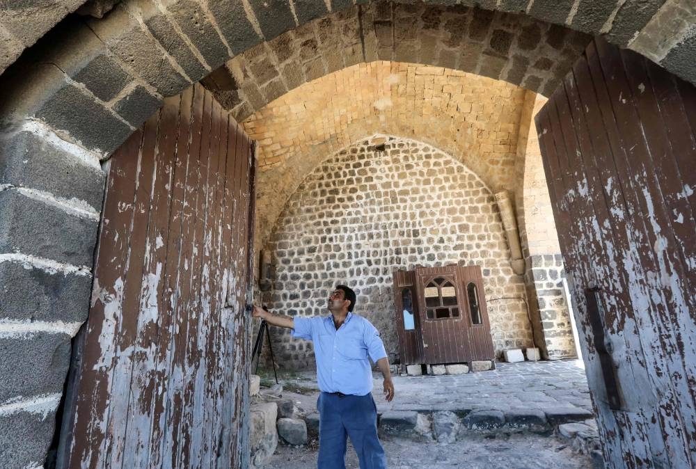 Younes Dayoub, the sole custodian of al-Marqab castle opens the gate at the premises near the city of Baniyas along the Mediterranean sea coast in Syria's western Tartus province on July 25, 2022. — AFP pic