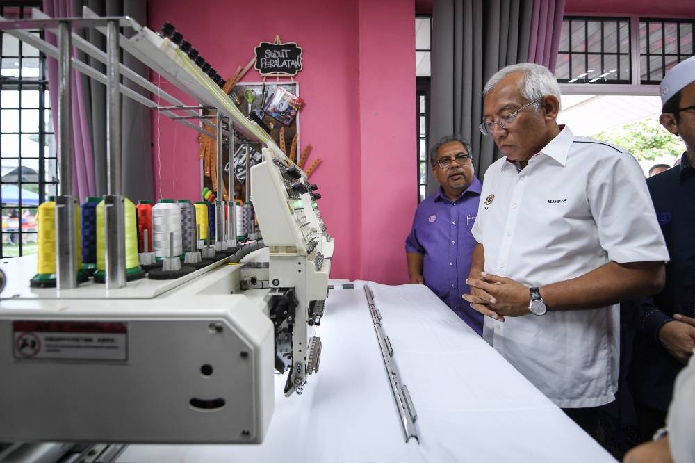 Rural Development Minister Datuk Seri Mahdzir Khalid looks at an embroidery machine after the launch of the Centre of Empowerment (COME) in Kuala Nerang August 21, 2022. — Bernama pic