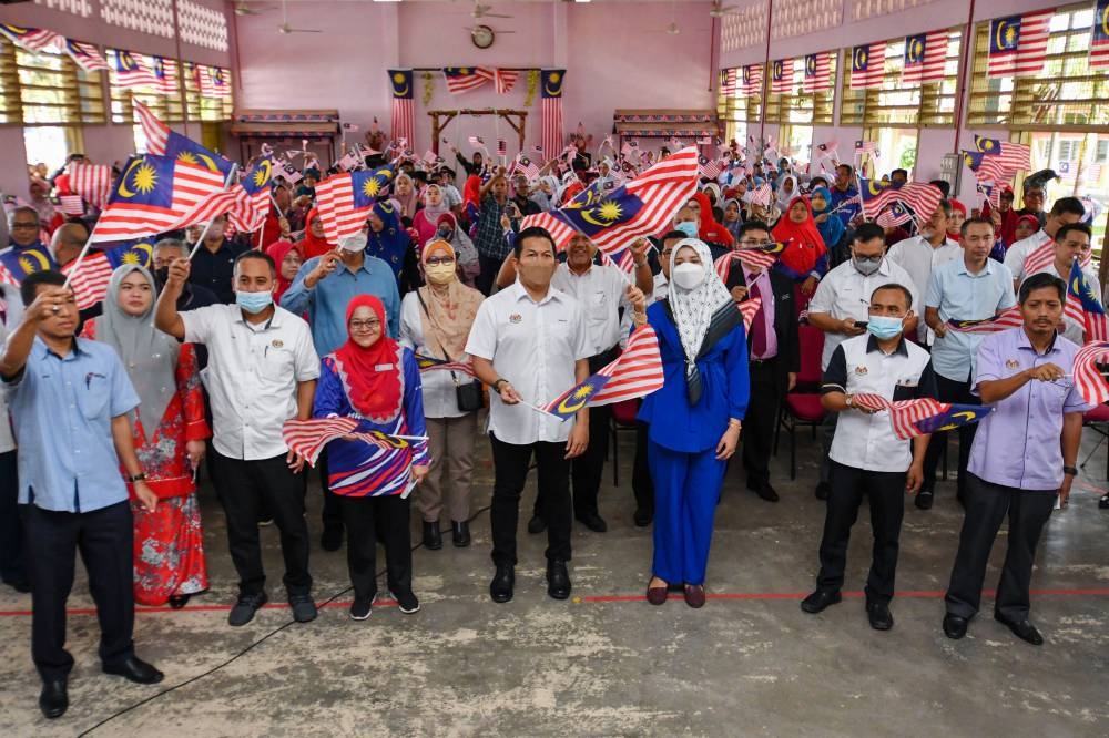 Deputy Finance Minister I Datuk Mohd Shahar Abdullah (centre) waves the Jalur Gemilang during the Kadok state constituency-level Merdeka@Komuniti Keluarga Malaysia Programme at Sekolah Kebangsaan (SK) Kadok, Ketereh August 21, 2022. — Bernama pic