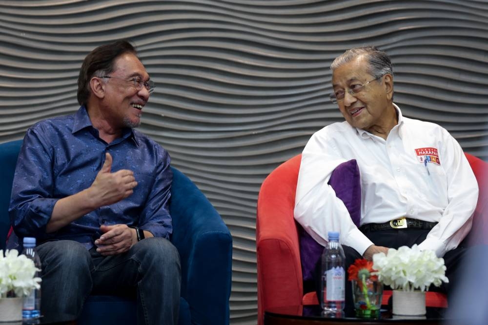 Datuk Seri Anwar Ibrahim and Tun Dr Mahathir share a light moment during a PKR programme in Port Dickson July 19, 2019. — Picture by Ahmad Zamzahuri